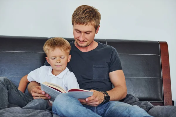 Βιβλίο Στα Χέρια Πατέρας Και Γιος Είναι Στο Σπίτι Μαζί — Φωτογραφία Αρχείου