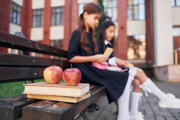 Assis Lisant Deux Écolières Sont Dehors Près Bâtiment École — Photo