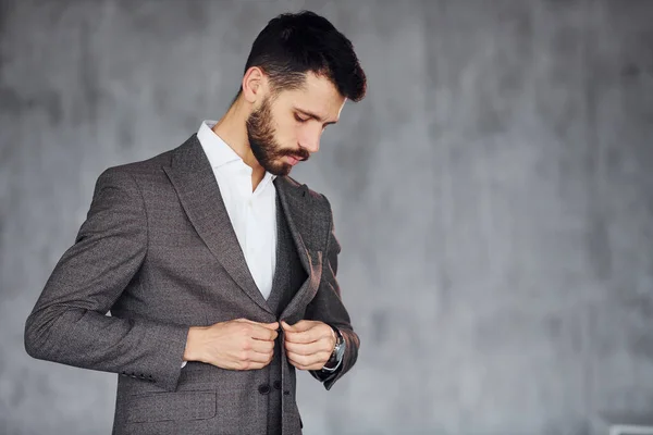 Steht Vor Grauem Hintergrund Junger Stilvoller Geschäftsmann Anzug Drinnen Erfolgskonzept — Stockfoto