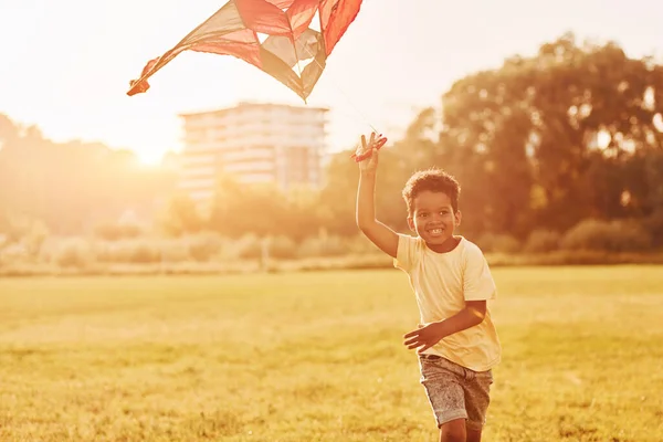 赤い凧 アフリカ系アメリカ人の子供は夏の昼間にフィールドで楽しんでいます — ストック写真
