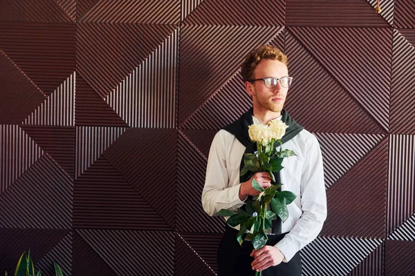 Man holds flowers. Indoors of new modern luxury restaurant.