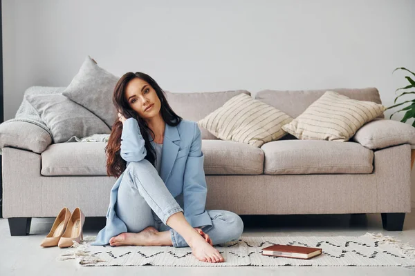 At home in blue jacket. European woman in fashionable stylish clothes is posing indoors.