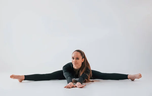 Siyah Elbiseli Spor Elbiseli Genç Bir Kadın Içeride Jimnastik Yapıyor — Stok fotoğraf