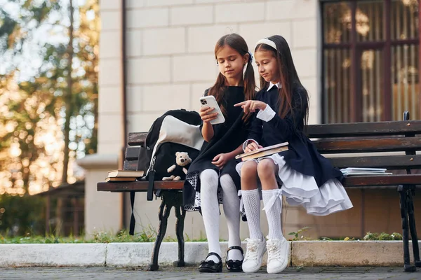 Zwei Schülerinnen Sitzen Zusammen Draußen Der Nähe Des Schulgebäudes — Stockfoto
