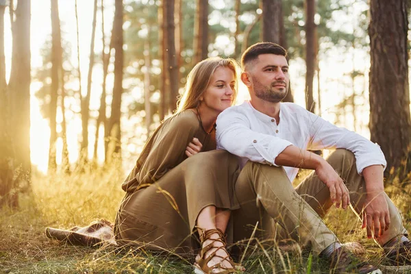 Resting in the forest. Happy couple is outdoors at daytime.