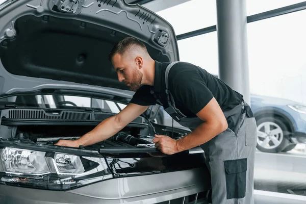 Bajo Capó Hombre Uniforme Trabaja Autosalón Durante Día — Foto de Stock