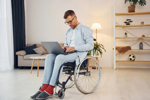 Mit Laptop Auf Den Beinen Behinderter Mann Rollstuhl Ist Hause — Stockfoto