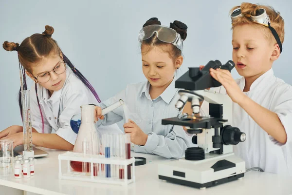 Помощью Микроскопа Дети Белых Халатах Играют Ученых Лаборатории Помощью Оборудования — стоковое фото