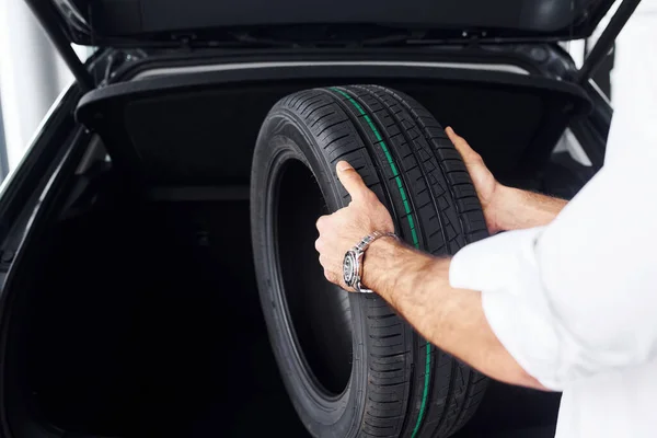 Man White Shirt Holds Automobile Tire Indoors Modern Car — Stock Photo, Image