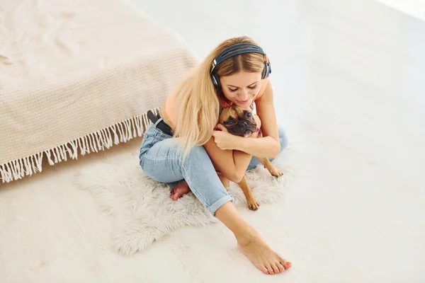 床に座って 犬を飼っている女性は昼間家にいます — ストック写真