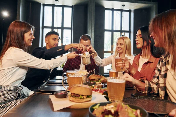 Com Roupas Casuais Grupo Jovens Amigos Sentados Juntos Bar Com Imagem De Stock