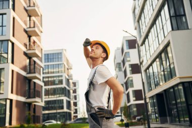 Binalara bakıyorum. Gündüz vakti inşaatta üniformalı genç bir adam çalışıyor..