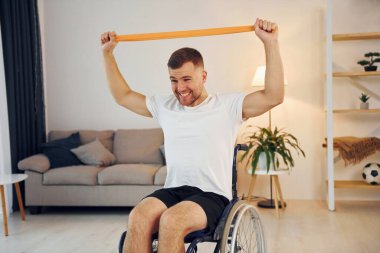 Ellerini uzat. Tekerlekli sandalyedeki engelli evde..