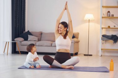 Yoga çalışıyorum. Anne ve küçük kızı evde birlikteler..