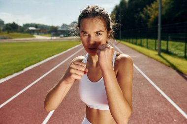Kickboks çalışıyorum. Spor elbiseli genç bayan dışarıda egzersiz yapıyor..