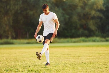 Profesyonelce. Genç futbolcu spor sahasında antrenman yapıyor..