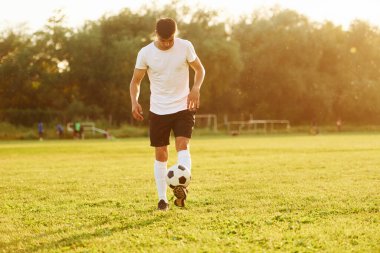 Sadece bir kişi. Genç futbolcu spor sahasında antrenman yapıyor..