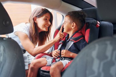 Küçük çocuklu kadın gündüz vakti modern otomobilde..