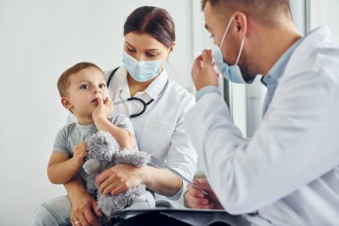Nitelikli yardım. Beyaz önlüklü iki doktor klinikte birlikte çalışıyorlar..
