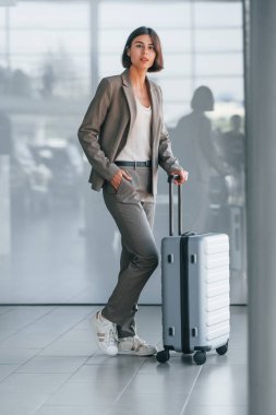 Yansımalı duvara yaslan. Bagajlı kadın içeride bekliyor. Turizm kavramı.