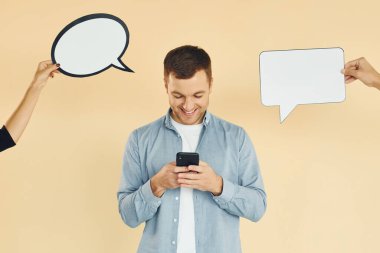 Akıllı telefonu tutuyorsun. Bir sürü fikir. Stüdyoda duran adam mesaj için boş tabelalarla.