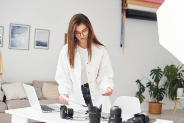 Günlük kıyafetli kadın fotoğrafçı gündüzleri evde çalışıyor..
