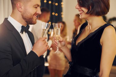 Neşeli bir çift. Bir grup insan içeride yeni yıl partisi veriyor..