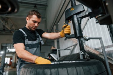 Güçlü eller. Üniformalı adam otomobil servisinde çalışıyor..