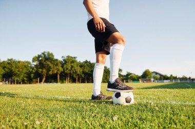 Güneşli bir gün. Genç futbolcu spor sahasında antrenman yapıyor..