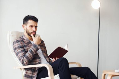 Kitap okuyor. Takım elbiseli genç bir iş adamı. Başarı kavramı.