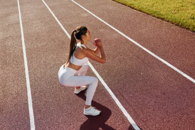 Spor elbiseli aktif genç bayan dışarıda egzersiz yapıyor..