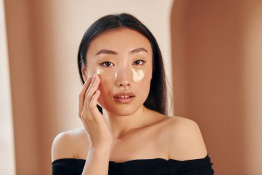 Güzellik anlayışı. Genç ciddi Asyalı kadın içeride duruyor..