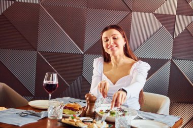 Güzel bir kadın masaya oturur. Yeni lüks restoranın içinde..