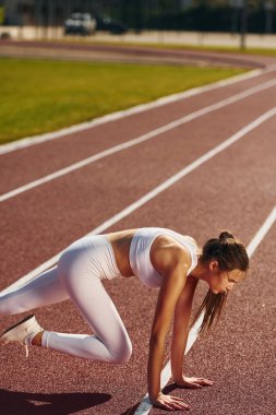 Esneme egzersizleri. Spor elbiseli genç bayan dışarıda spor yapıyor..