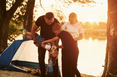 Tatil kavramı. Anne, baba ve çocukların ailesi kampta..
