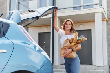 Alışverişten sonra. Gündüz vakti elektro-mobil arabasıyla gezen genç bir kadın..