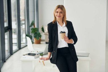 Resmi kıyafetli kadın gündüz vakti modern ofiste kapalı..