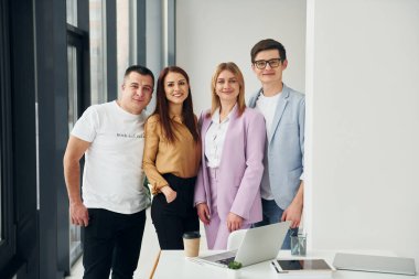 Birlikte duruyoruz. Ofiste resmi giysiler içinde bir grup insan var..