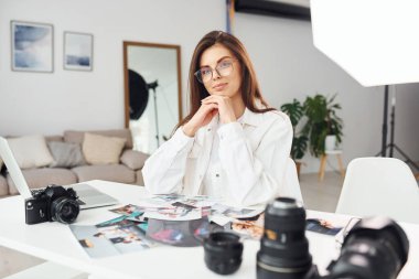 Günlük kıyafetli kadın fotoğrafçı gündüzleri evde çalışıyor..