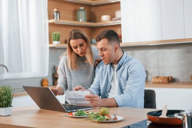 Eğleniyorum. Modern mutfakta yemek hazırlayan bir çift..