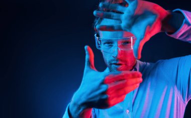 Sanal gerçeklik kavramı. Neon ışıkları. Genç Avrupalı adam karanlık stüdyoda..