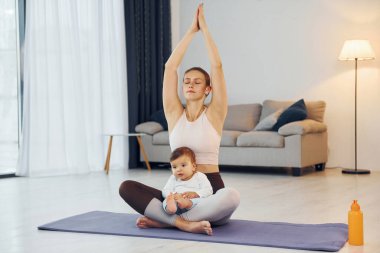 Yoga egzersizleri yapıyorum. Anne ve küçük kızı evde birlikteler..