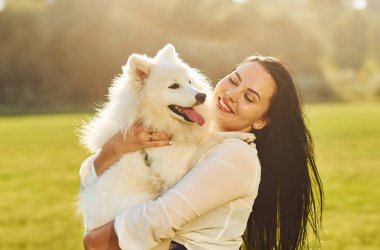 Kadın tarlada sevimli köpeğiyle oturuyor..