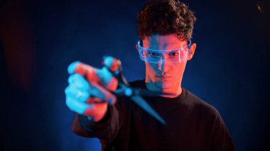 Portreyi kapat. Neon ışıkları. Genç Avrupalı adam karanlık stüdyoda..