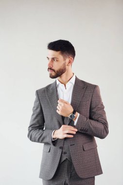 Beyaz arka planda kamera için poz vermek. Takım elbiseli genç bir işadamı..