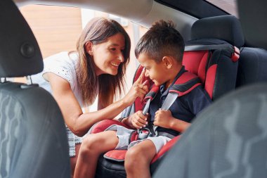 Küçük çocuklu kadın gündüz vakti modern otomobilde..