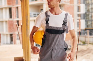 Büyük proje. Gündüz vakti inşaatta üniformalı genç bir adam çalışıyor..