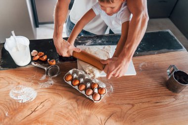 Küçük yardımcı. Baba küçük oğluna Noel kurabiyeleri hazırlıyor..