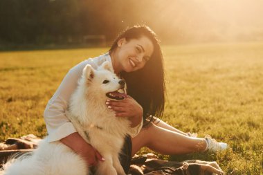 Köpeğiyle birlikte bir kadın güneşli bir günde sahada eğleniyor. Güzel güneş ışığı.