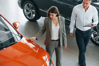 Yukarıdan bak. Resmi kıyafetli adam, müşteriye otomobil seçiminde yardımcı oluyor..